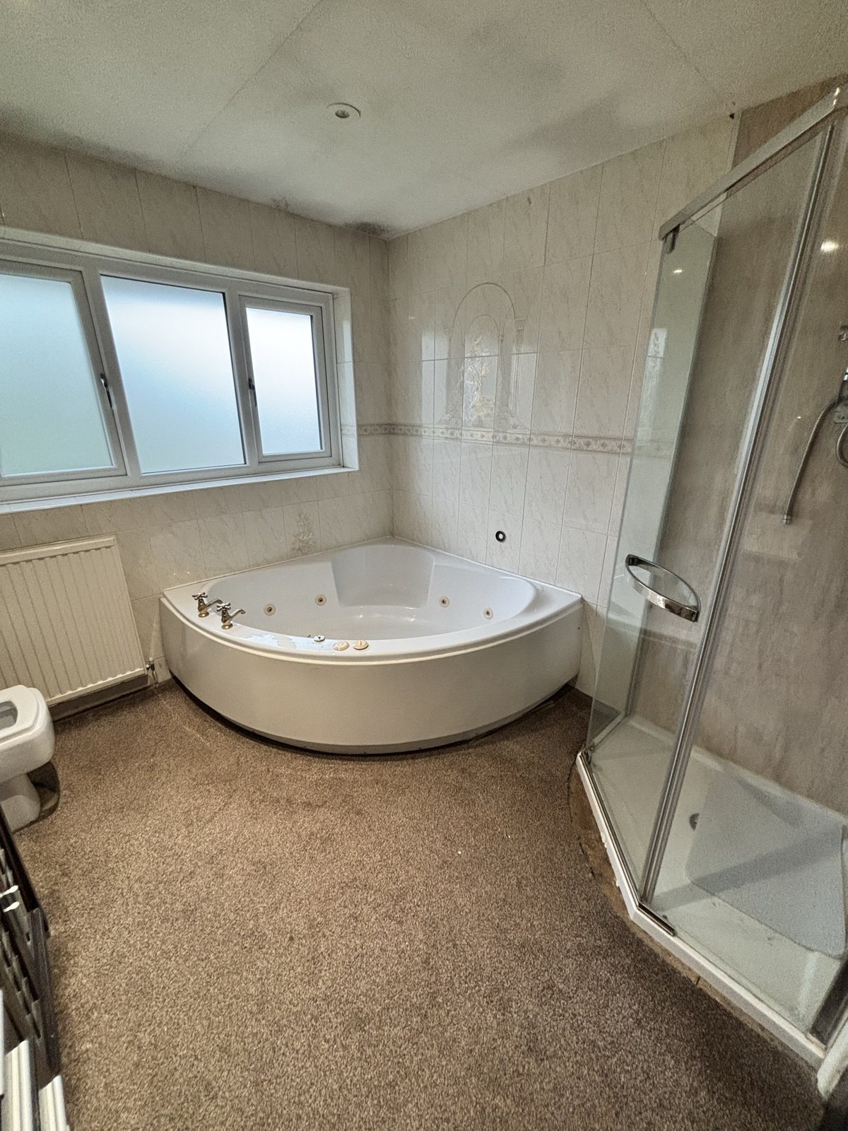 Ensuite before: dated suite, carpet and corner tub, Whitefield