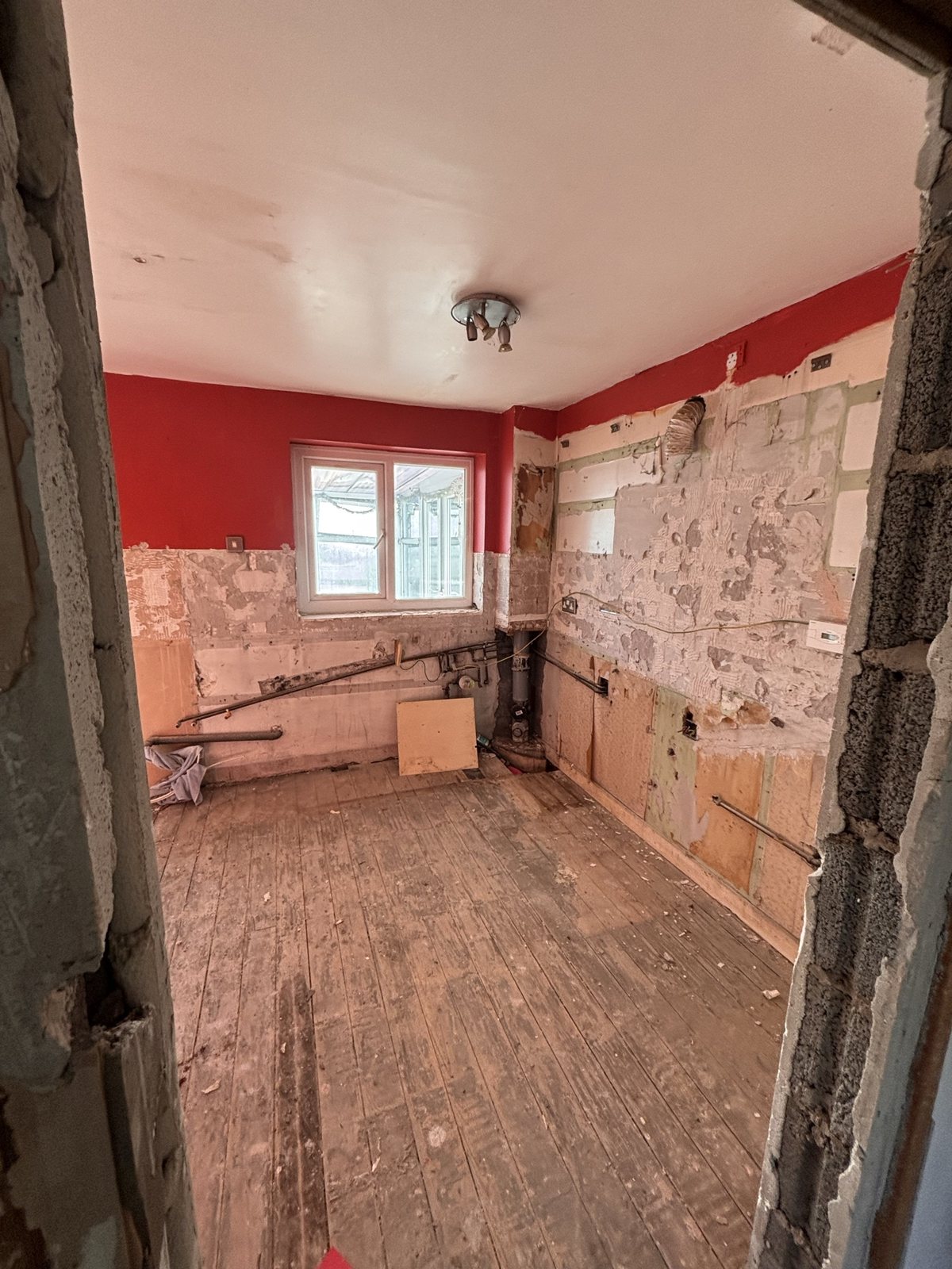 Kitchen before: room stripped to bare walls and floorboards