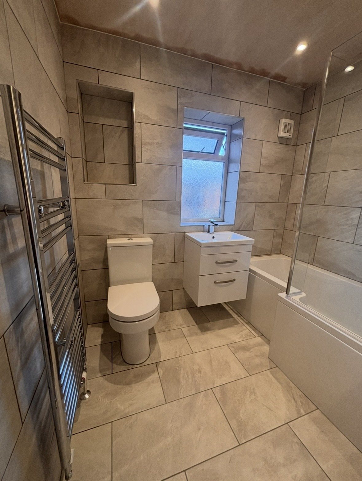 After: combined bathroom with floating vanity and tiled niche