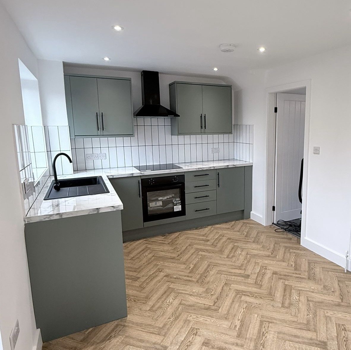 After: sage green kitchen with marble worktop and herringbone floor
